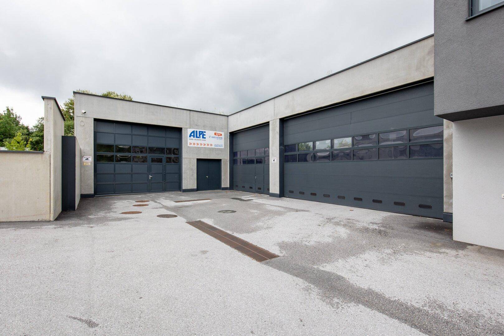 Große Garagentore aus Metall an einem modernen Gewerbegebäude, ideal für Lagerung oder Werkstatt.