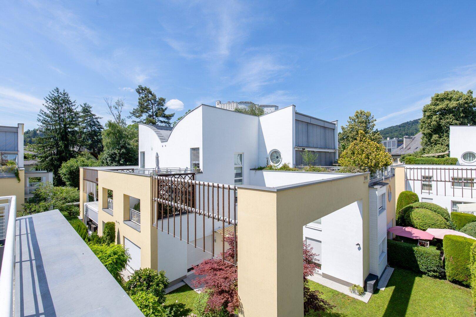 Wohnanlage mit moderner Architektur, begrünten Dächern und Blick auf die Umgebung.