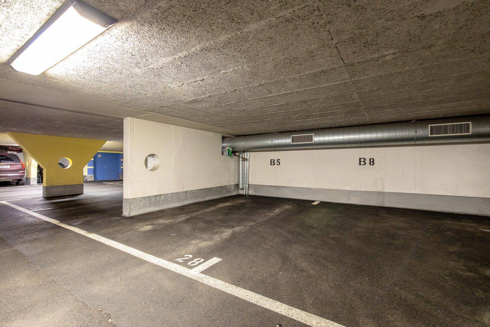 Tiefgaragenstellplatz in einer modernen Wohnanlage mit guter Beleuchtung.