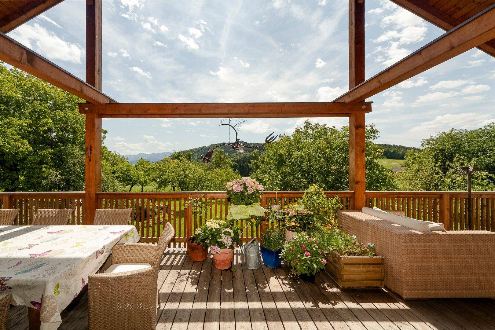Geräumige Holzterrasse mit Sitzgelegenheiten und weitem Blick in die Landschaft.