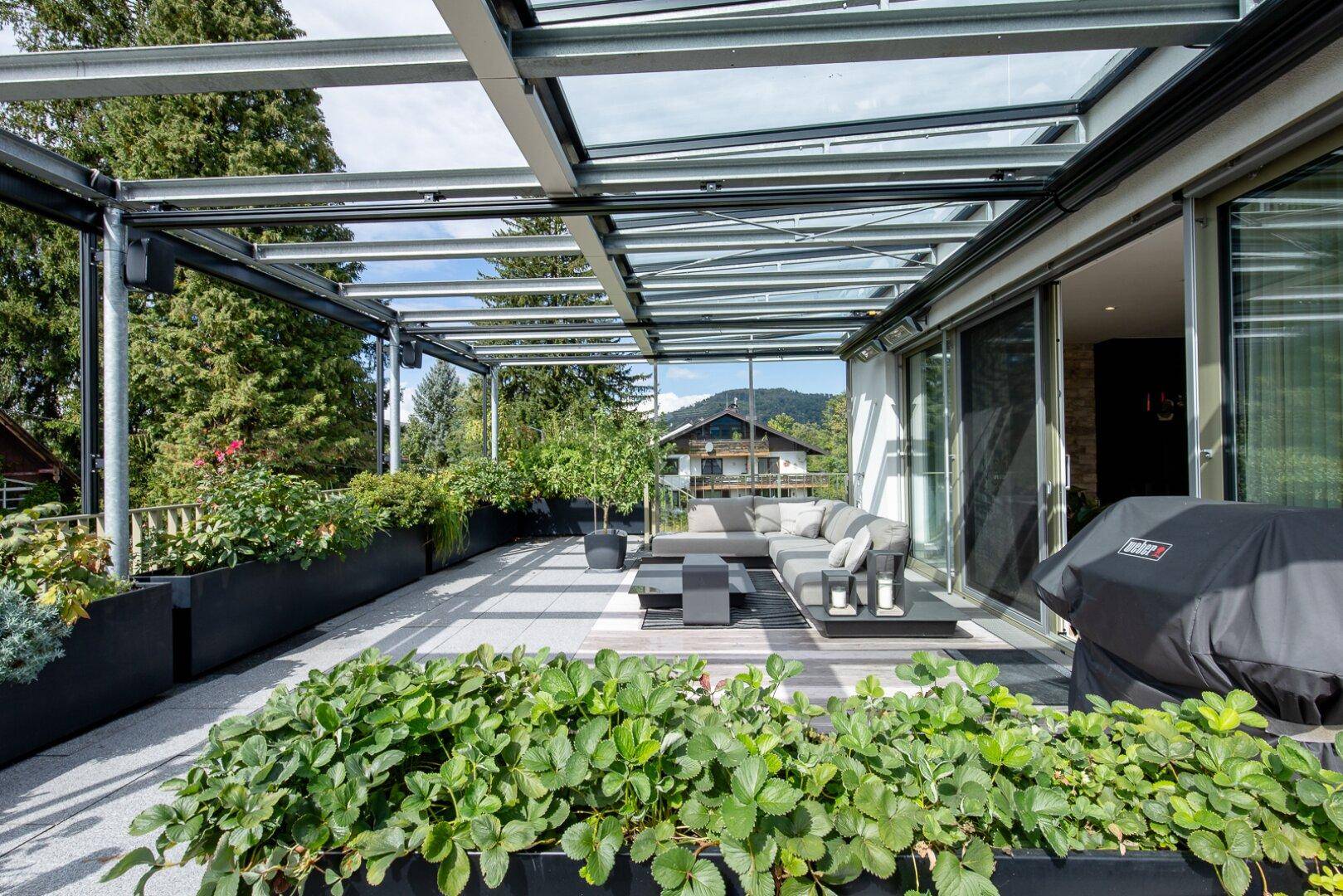 Geräumige Dachterrasse mit moderner Überdachung, bequemen Loungemöbeln und Grillbereich.