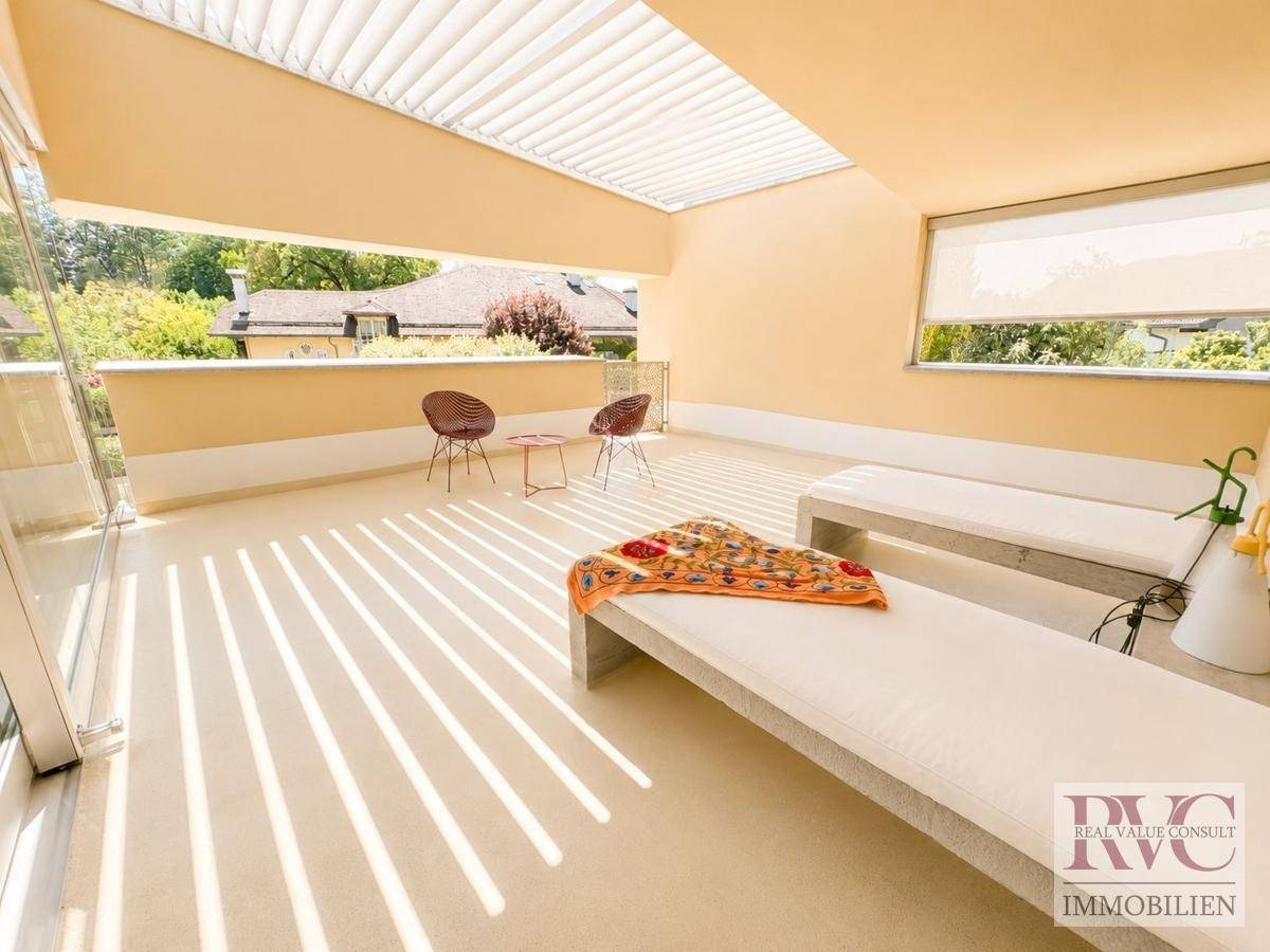 Sonniger Außenbereich mit Liegen und Pergola, ideal zum Entspannen im Freien.