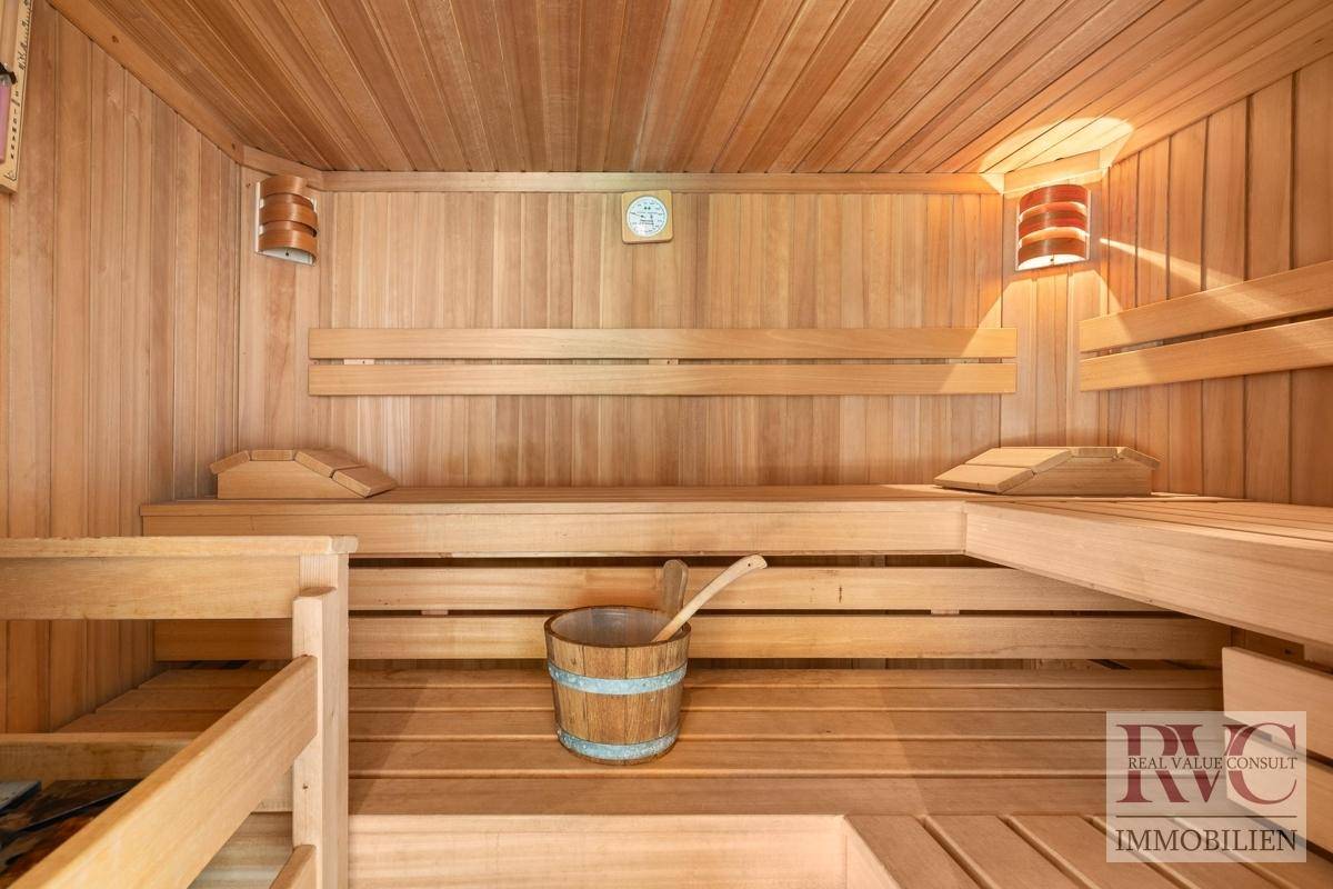 Gemütliche Holzsauna mit mehreren Bänken und traditionellem Aufgusseimer für pure Entspannung.