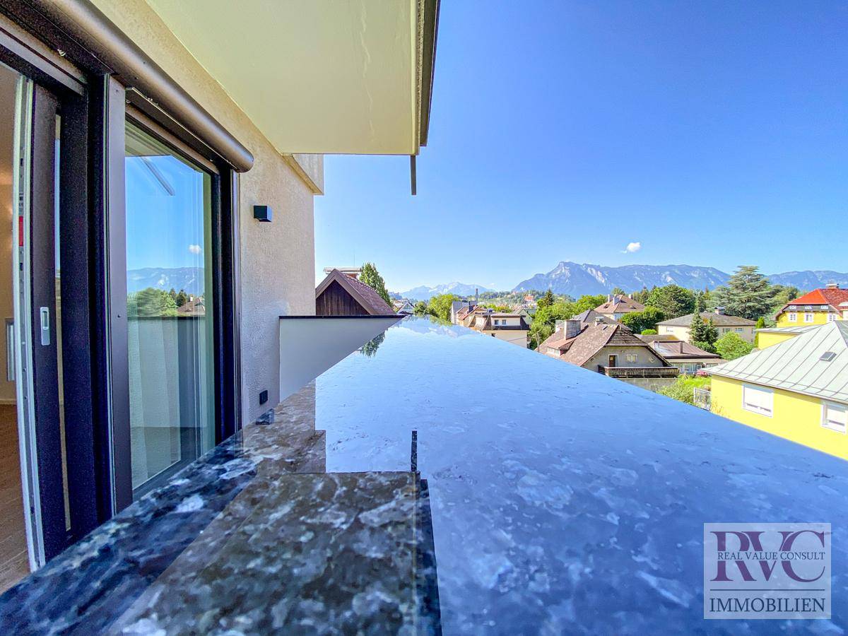 Balkon mit dunkler Brüstung und weitem Blick über die Stadt und die Berglandschaft.