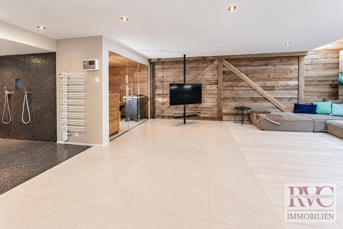 Geräumiger Wellnessbereich mit Sauna, Duschen und großzügiger Liegefläche.