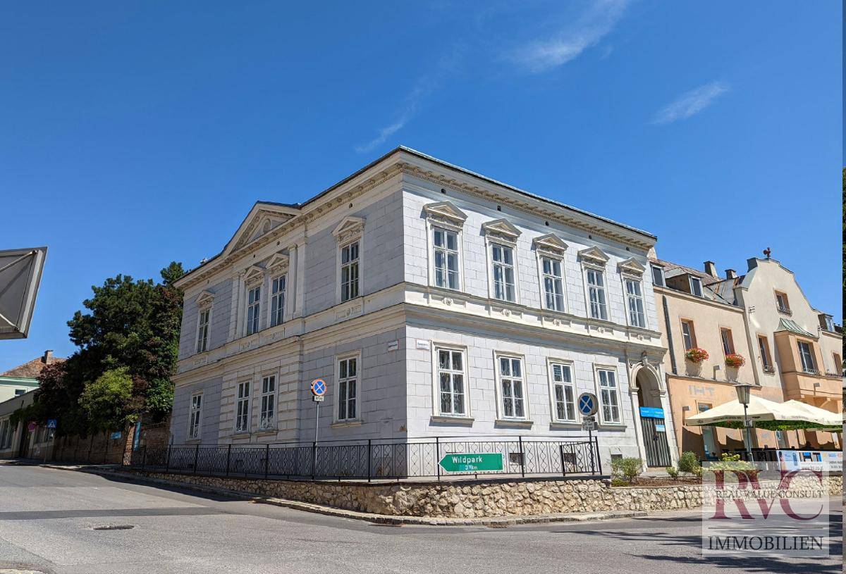 Elegantes historisches Gebäude an einer belebten Straßenecke mit angrenzendem Café.