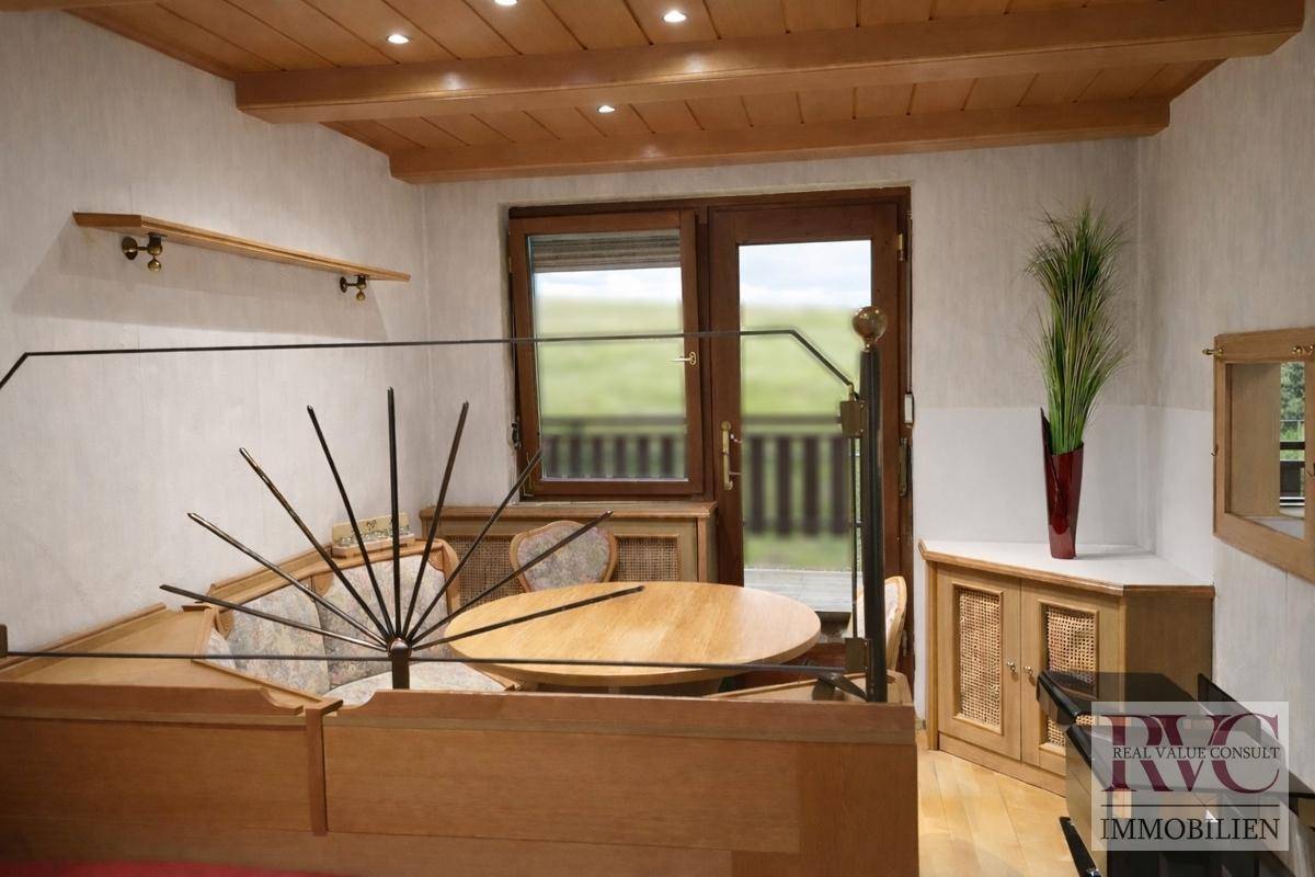 Gemütlicher Essbereich mit Holztisch, Eckbank und Zugang zu einem Balkon oder Terrasse.