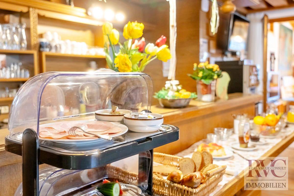 Reichhaltiges Frühstücksbuffet mit frischen Speisen, Brot und Kaffee in einladender Atmosphäre.