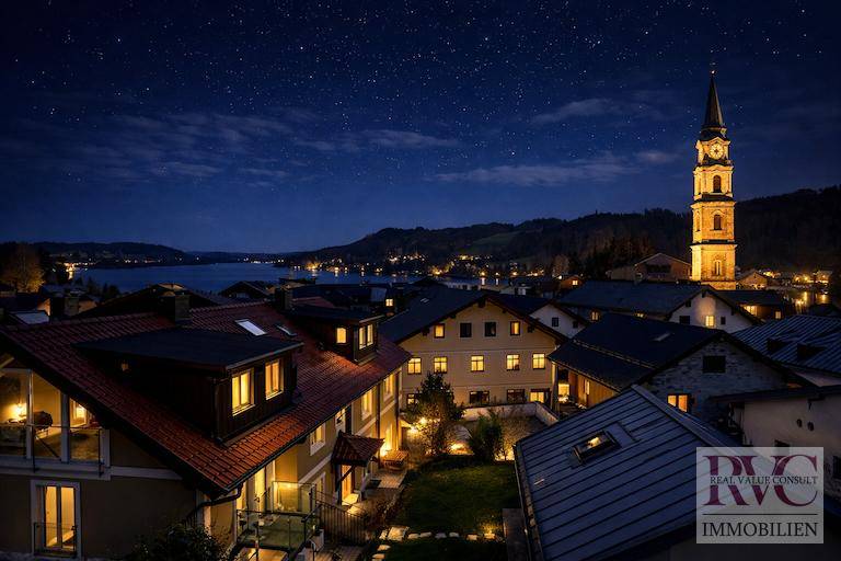 Malerische Nachtansicht einer Stadt am See mit beleuchteter Kirche und Sternenhimmel.
