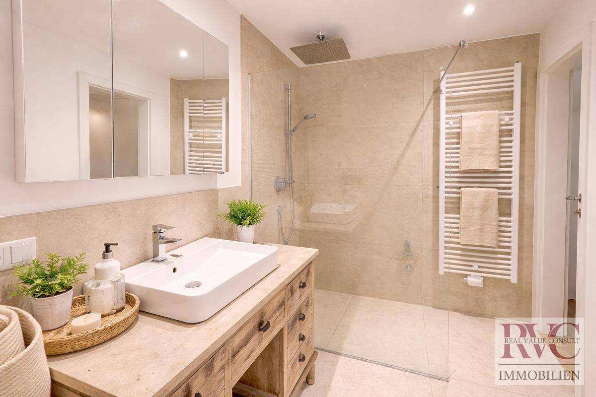 Modernes Badezimmer mit begehbarer Dusche, Einzelwaschbecken und beheiztem Handtuchhalter.