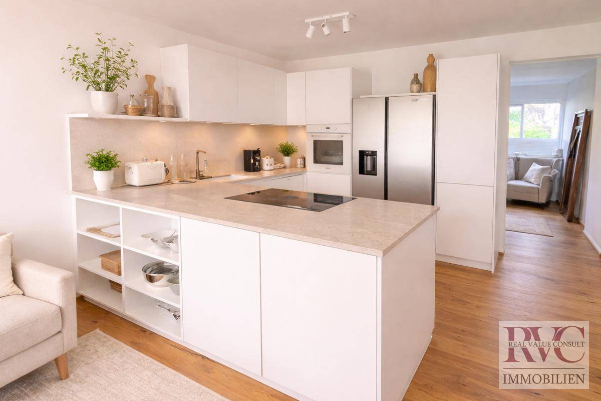 Moderne, offene weiße Küche mit Kochinsel, integrierten Geräten und hellem Holzfußboden.