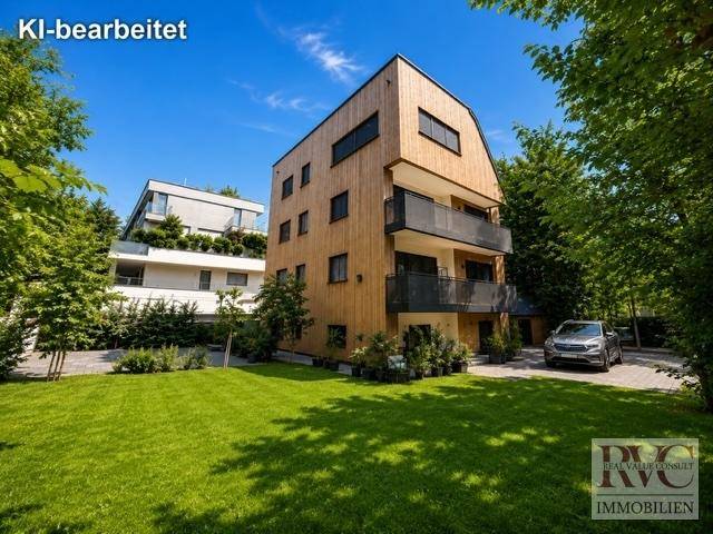 Modernes Gebäude mit Holzfassade und Balkonen, umgeben von einer grünen Rasenfläche.