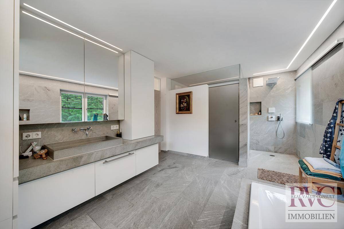 Modernes Badezimmer mit großformatigen Fliesen, Doppelwaschbecken und begehbarer Dusche.