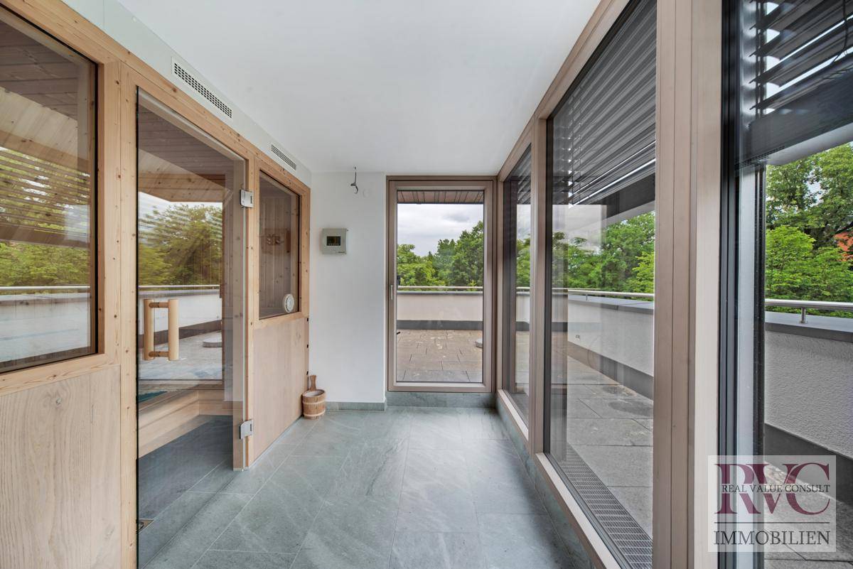 Heller Wellnessbereich mit Sauna und großen Fenstern, die viel Tageslicht hereinlassen.