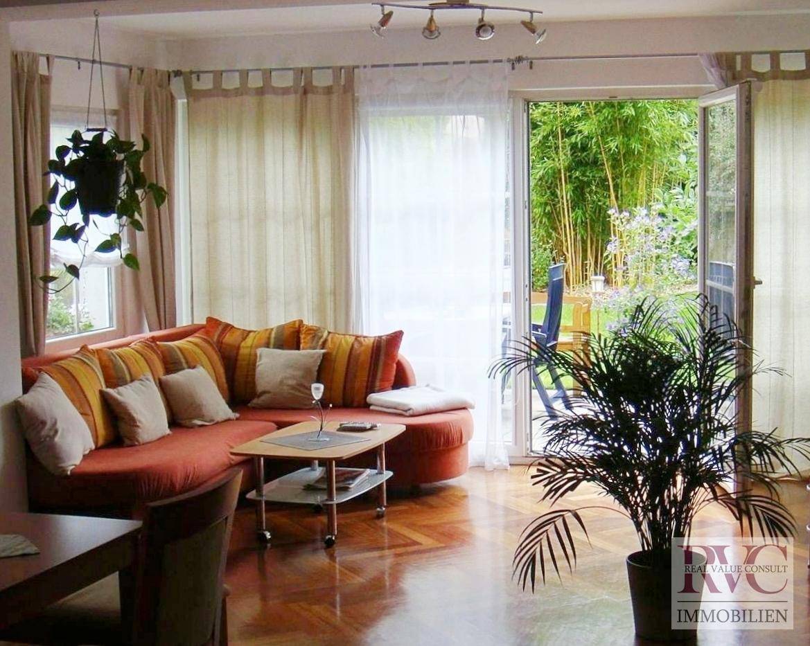Helles Wohnzimmer mit gemütlichem Sofa und direktem Zugang zur grünen Terrasse.