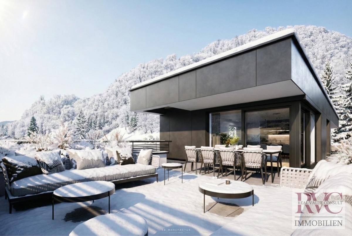 Geräumige Dachterrasse mit Lounge-Möbeln und Esstisch, umgeben von verschneiten Bergen.