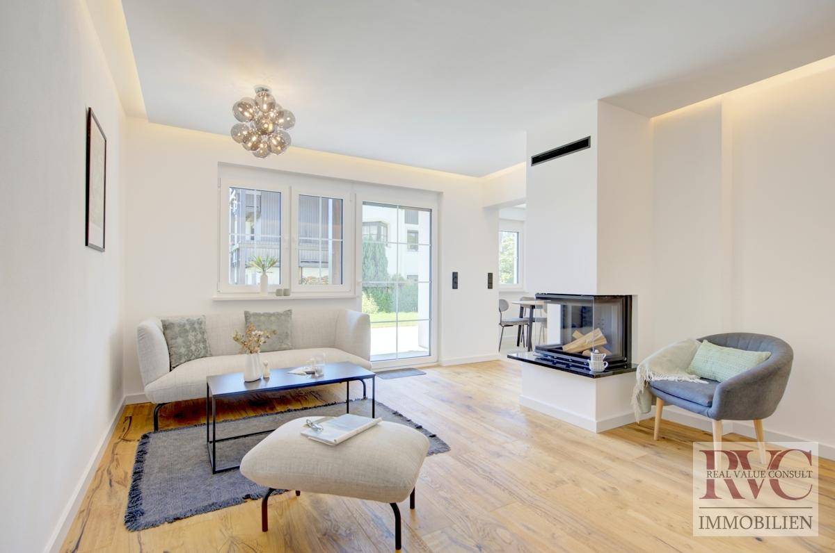 Modernes Wohnzimmer mit integriertem Kamin, bequemer Couch und großen Fenstern für viel Tageslicht.