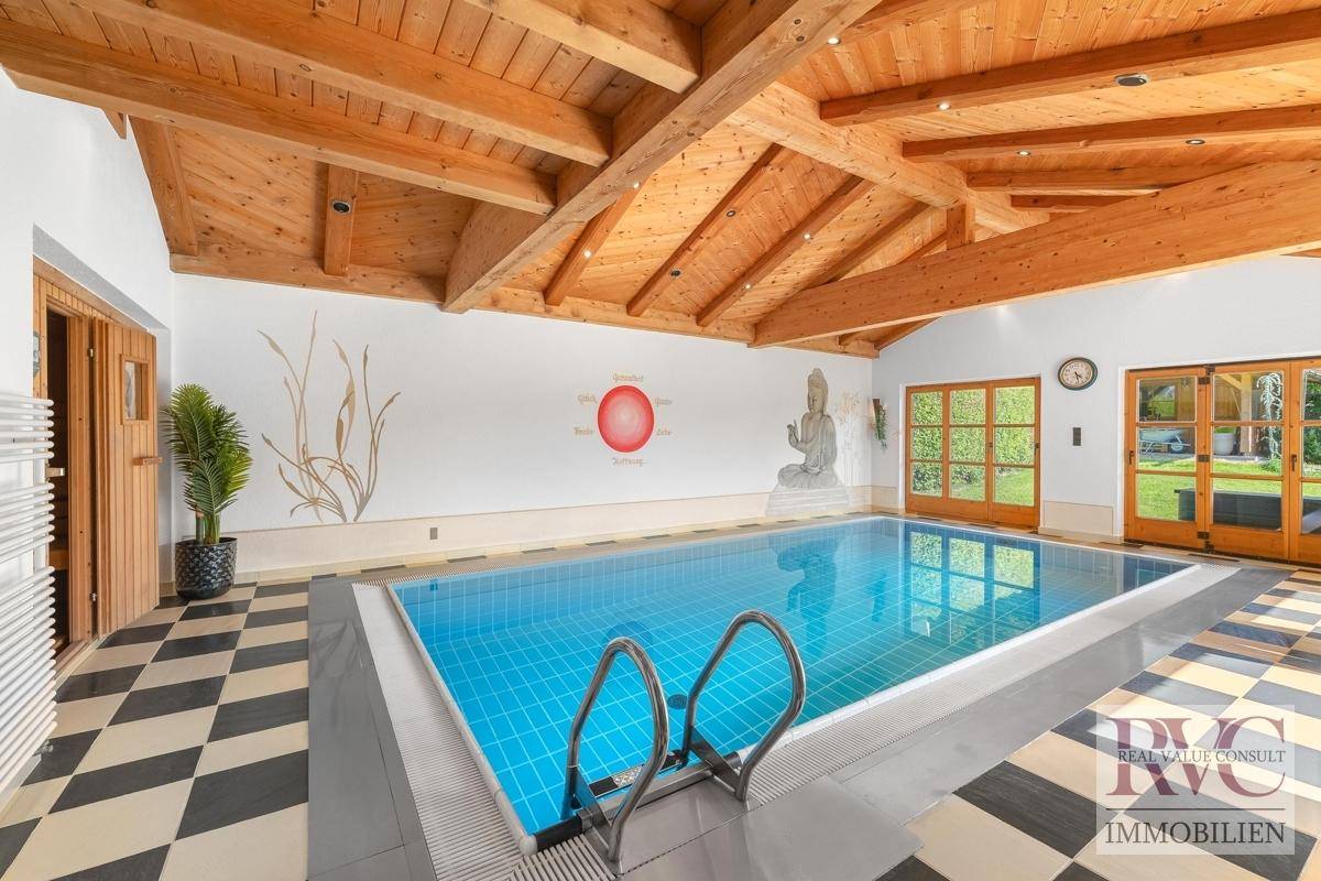 Großzügiger Innenpoolbereich mit Holzbalkendecke, Schachbrettfliesen und Wandmalerei für Entspannung.