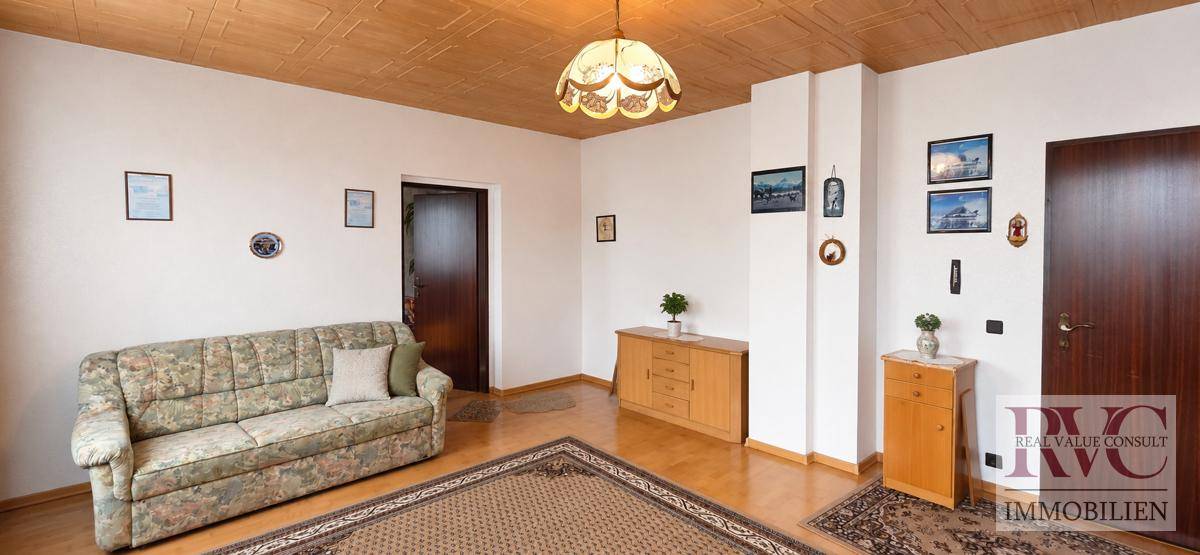 Wohnzimmer mit bequemer Couch, Teppich und Holzmöbeln, bietet eine warme Atmosphäre.