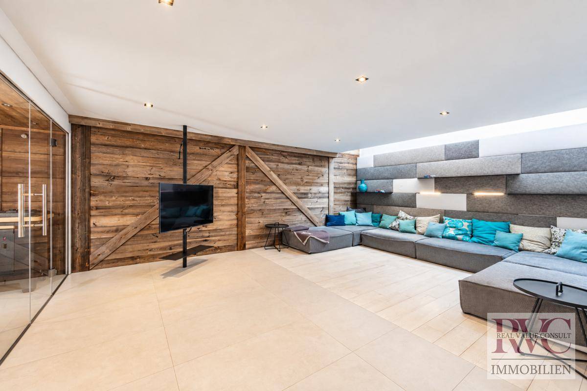 Entspannungsbereich im Wellnessbereich mit bequemen Sofas und Holzwandverkleidung.
