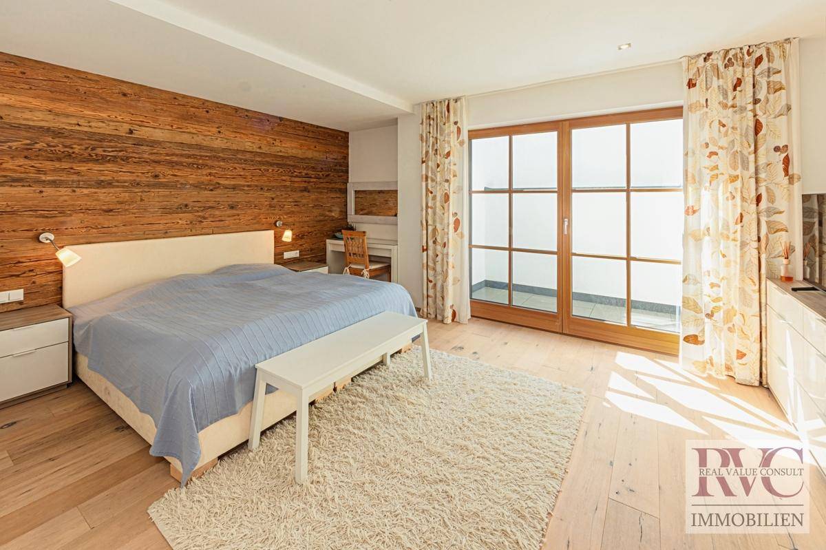 Komfortables Schlafzimmer mit Holzwand, Teppich und Balkonzugang.