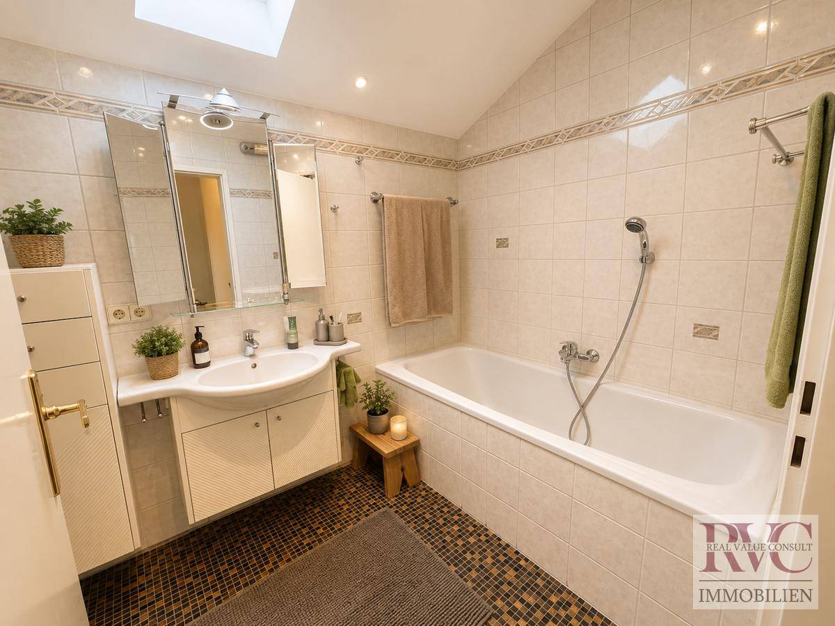 Badezimmer mit Badewanne, Einzelwaschbecken, Spiegelschrank und Mosaikfliesenboden.
