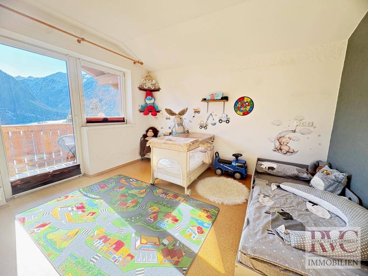 Helles Kinderzimmer mit Balkonzugang und Blick auf die Berge, ideal für kleine Bewohner.