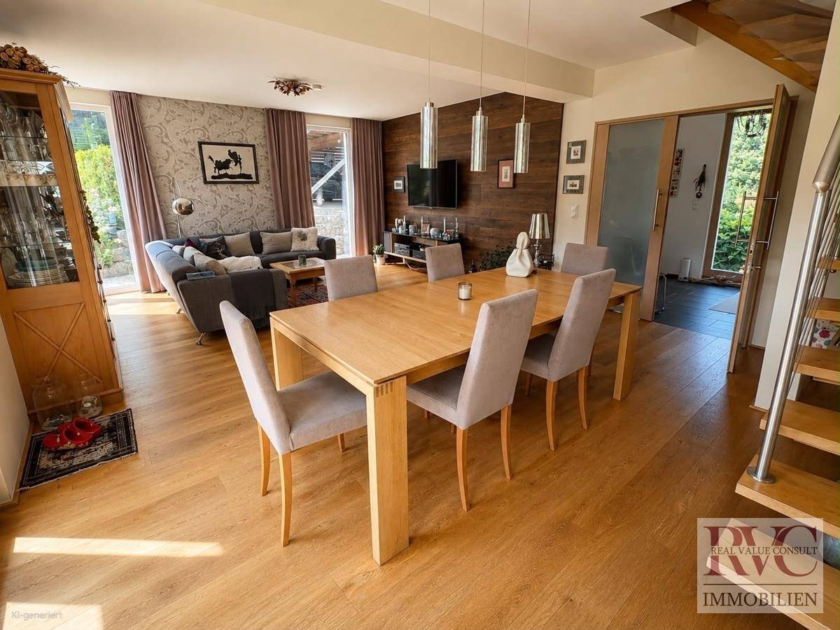 Geräumiger Wohn-Essbereich mit Holzboden, großem Esstisch und Zugang zur Terrasse.