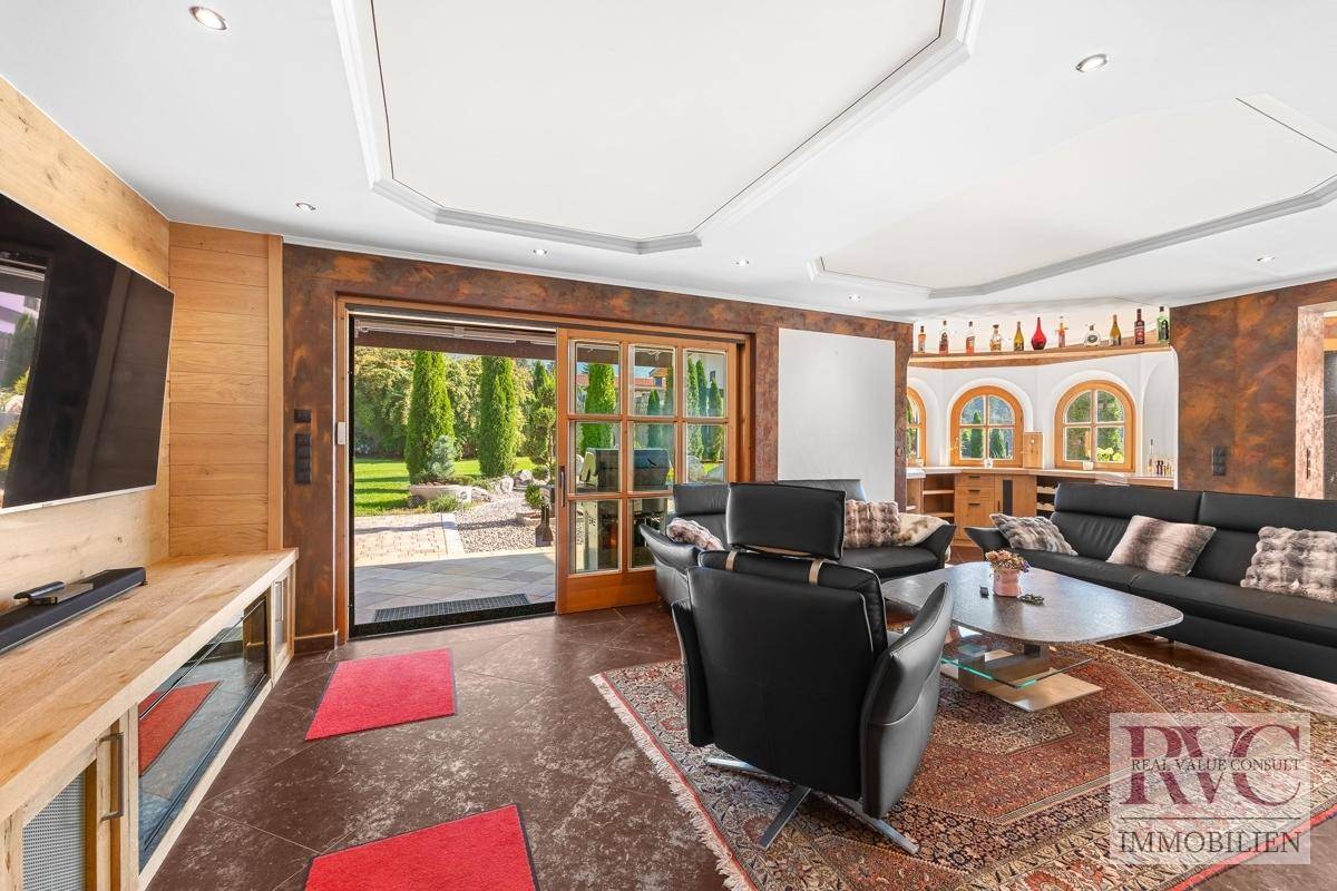Helles Wohnzimmer mit Zugang zum Garten durch große Schiebetüren und Blick ins Grüne.