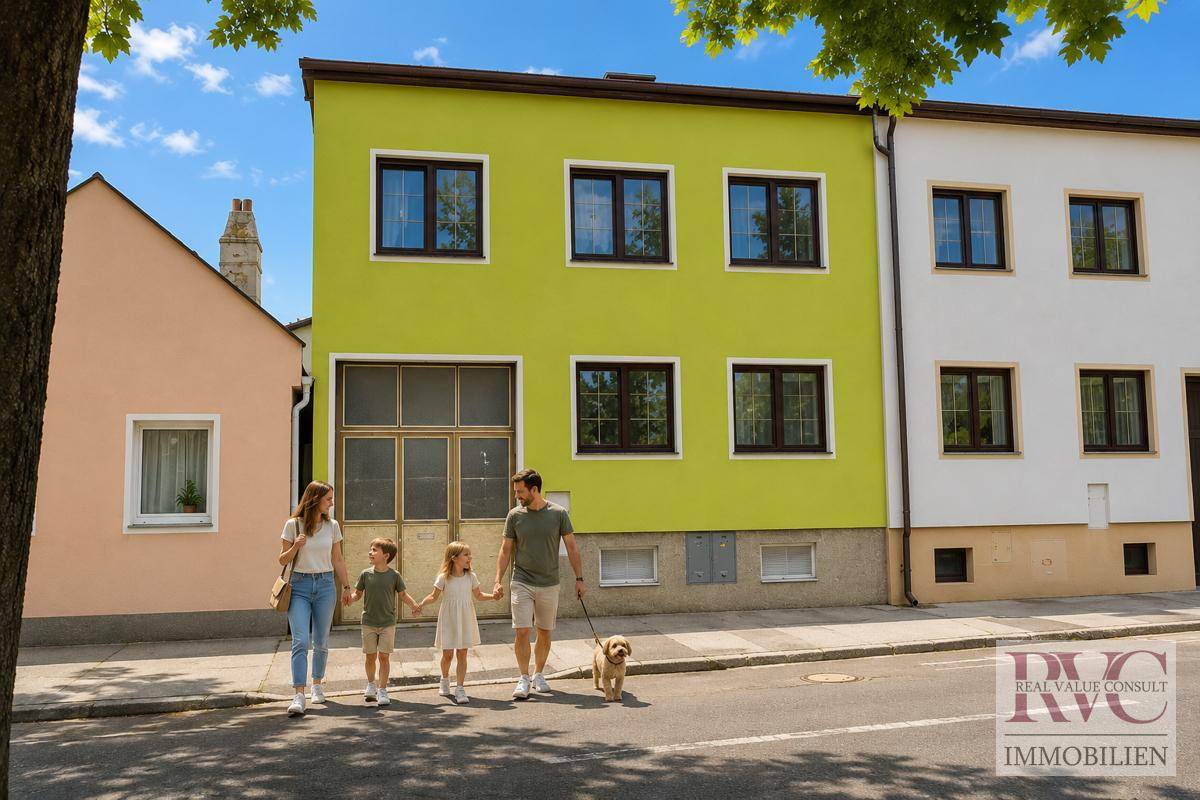 Eine Familie mit Hund spaziert vor einer Reihe von farbigen Wohnhäusern an einem sonnigen Tag.