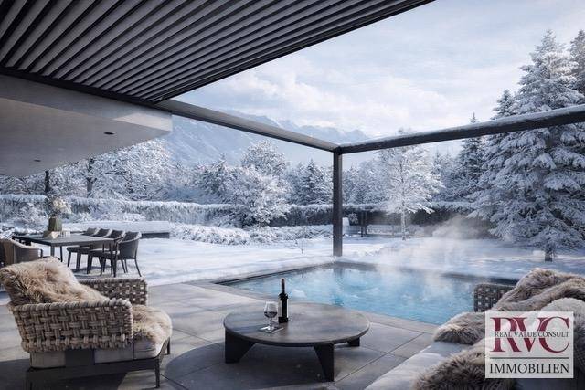 Exklusive Terrasse mit beheiztem Pool, gemütlichen Sitzgelegenheiten und Panoramablick auf die Berge.