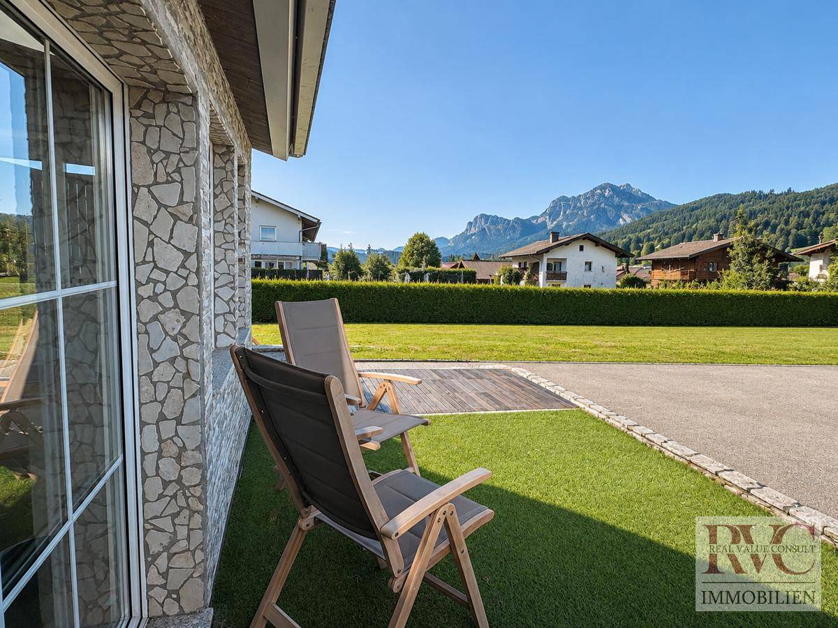 Gemütlicher Außenbereich mit Liegestühlen und weitem Blick auf die umliegenden Berge.