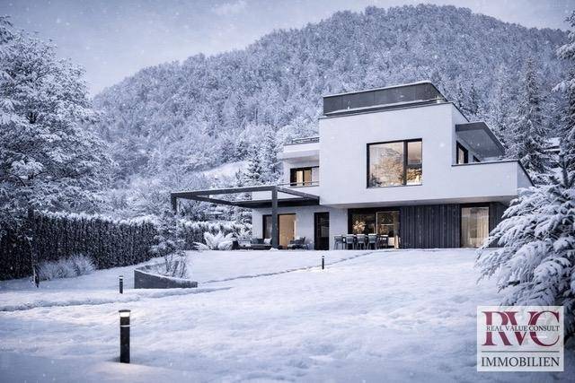 Elegante moderne Villa in einer idyllischen Winterlandschaft mit weitläufigem Gartenbereich.