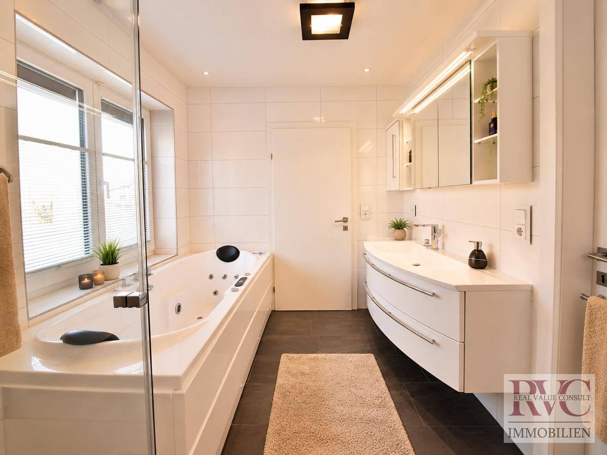 Modernes Badezimmer mit Whirlpool-Badewanne, Doppelwaschbecken und Fenster.