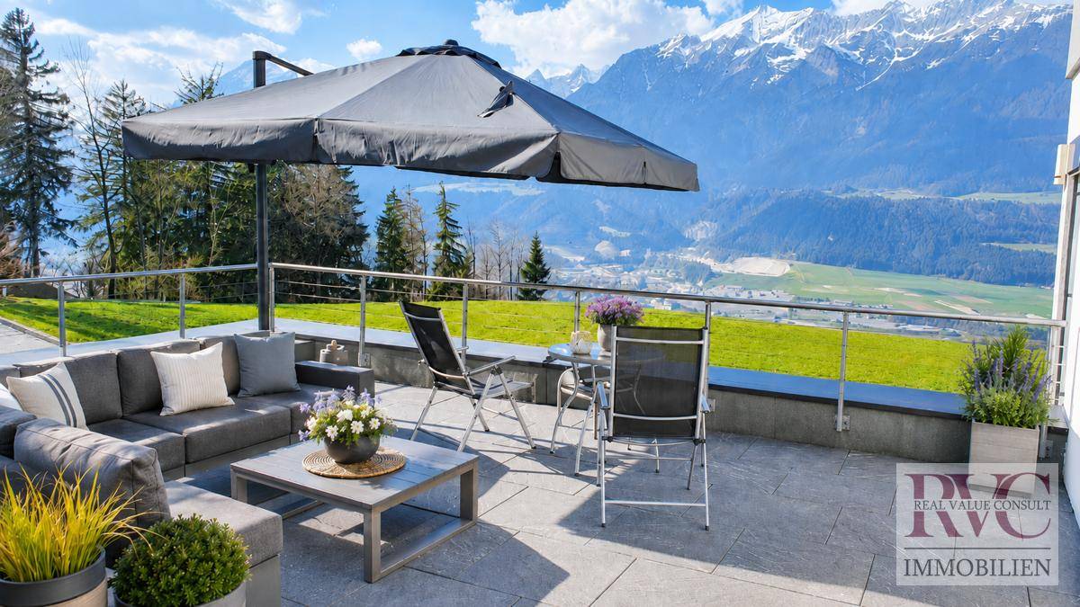 Große Terrasse mit bequemen Loungemöbeln und spektakulärem Bergblick.