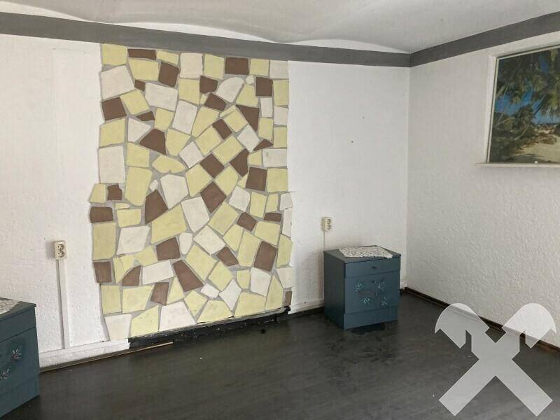 Schlafzimmer mit einer dekorativen Mosaikwand und zwei Nachttischen, bereit zur Einrichtung.
