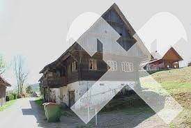 Historisches Holzhaus mit Satteldach und rustikalem Charme in ländlicher Umgebung.