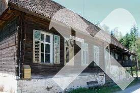 Älteres Holzhaus mit traditionellen Fensterläden und sichtbaren Gebrauchsspuren.