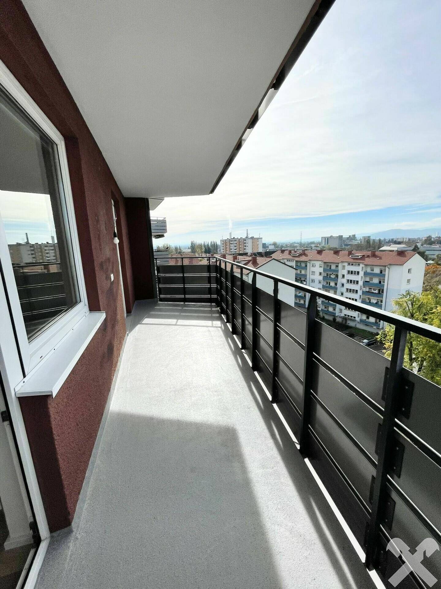 Langer Balkon mit moderner Brüstung und weitem Ausblick über die städtische Umgebung.