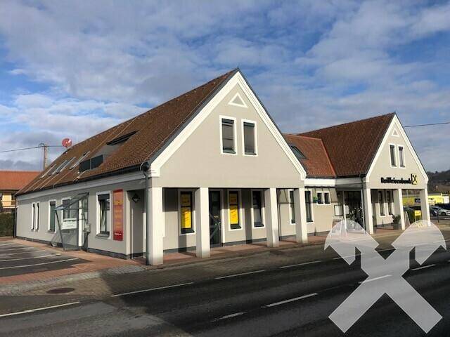 Gesamtansicht des Gebäudes von der Straße aus, mit Giebeldächern und großen Fenstern im Erdgeschoss.