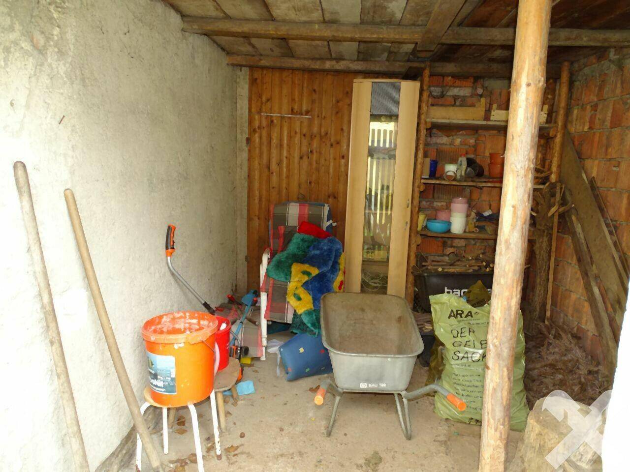 Abstellraum oder Schuppen mit verschiedenen Gegenständen, Schubkarre und Werkzeugen.
