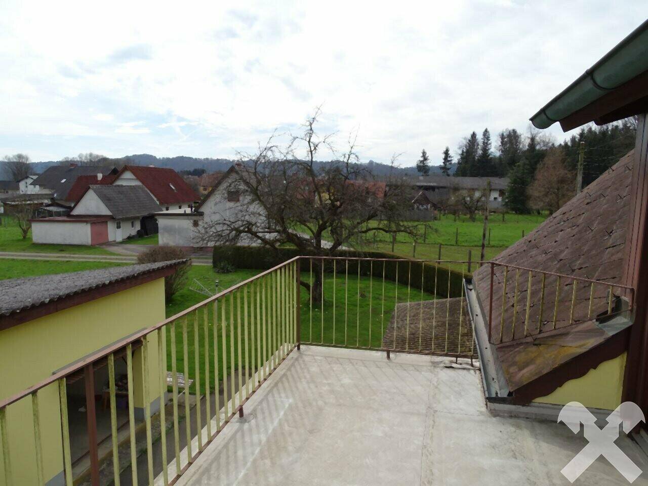 Blick vom Balkon auf die Seite des Hauses und die ländliche Umgebung.