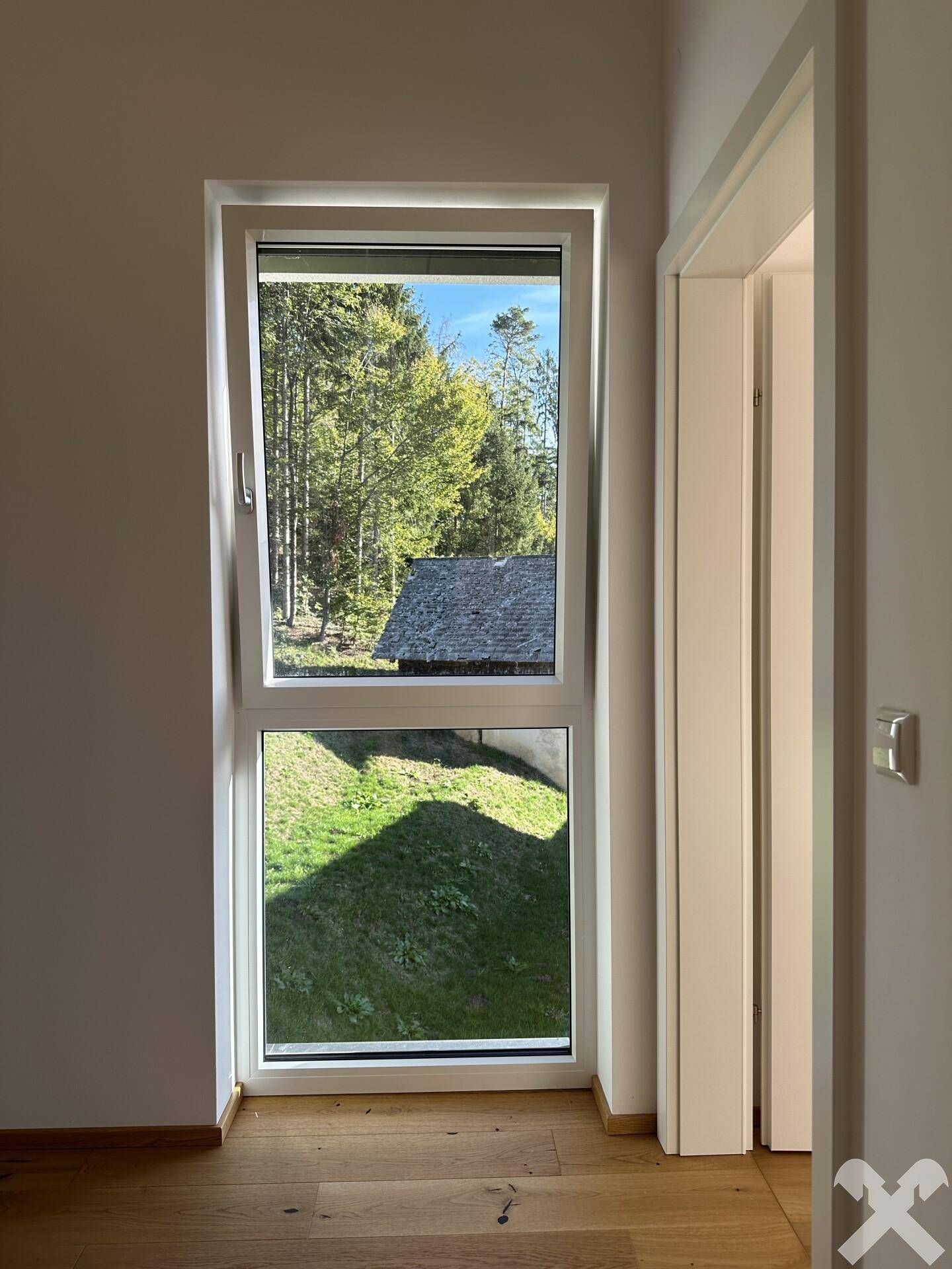Helles Zimmer mit Fenster, das einen angenehmen Blick auf die umliegende grüne Natur freigibt.