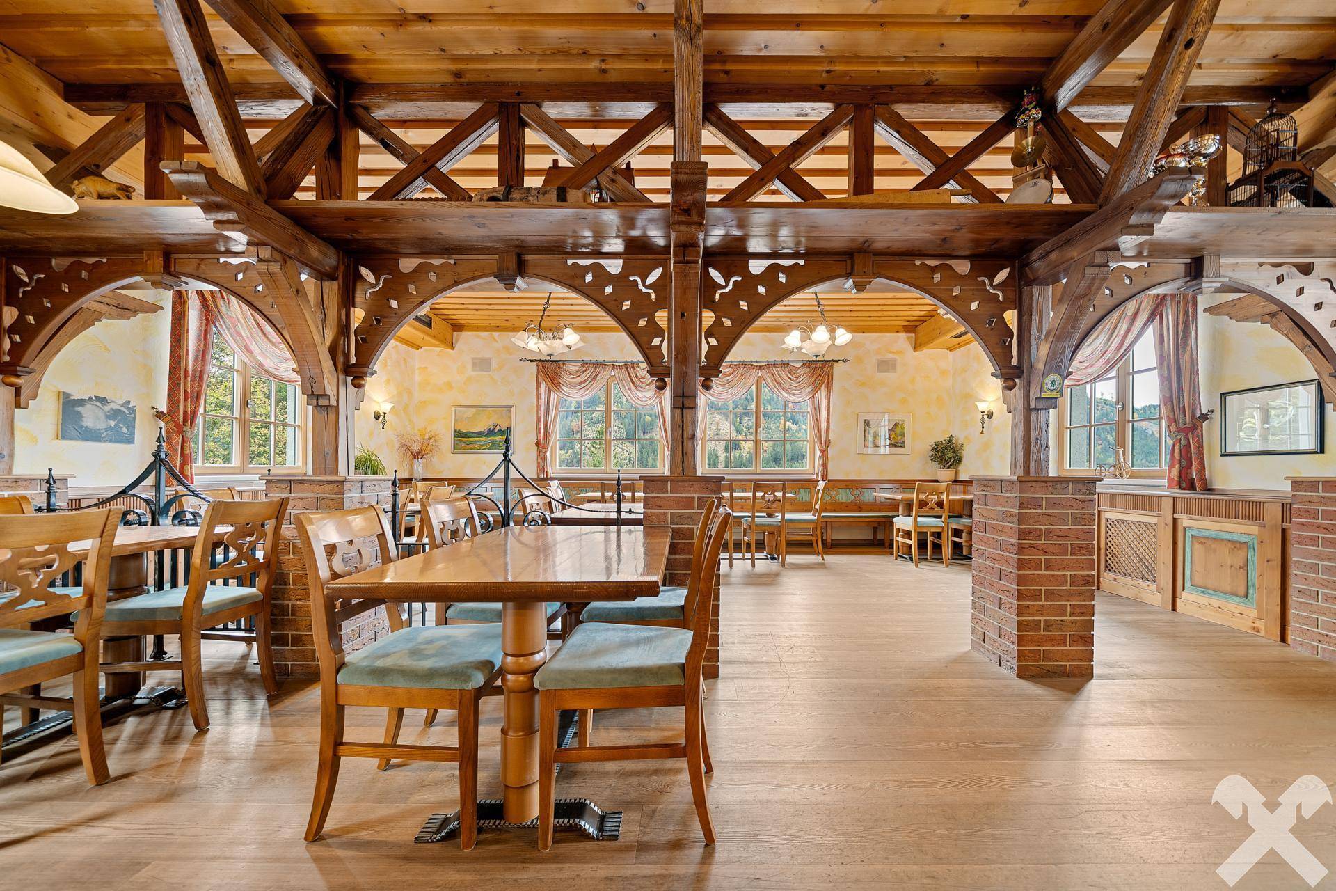 Geräumiger Speisesaal mit Holzbalken, großen Fenstern und traditionellen Holztischen und Stühlen, bietet viel Platz.