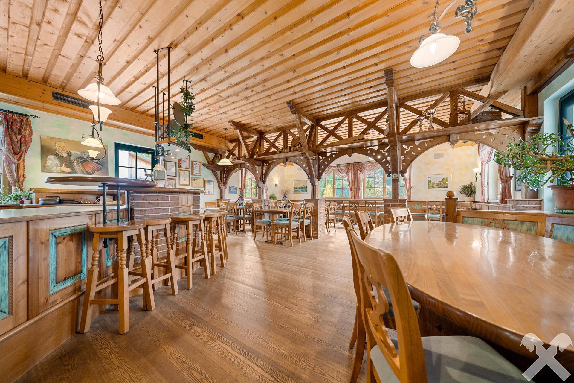 Gemütlicher Speisesaal im traditionellen Stil mit Holzbalkendecke, Holzböden und rustikalen Holzmöbeln, hell und einladend.
