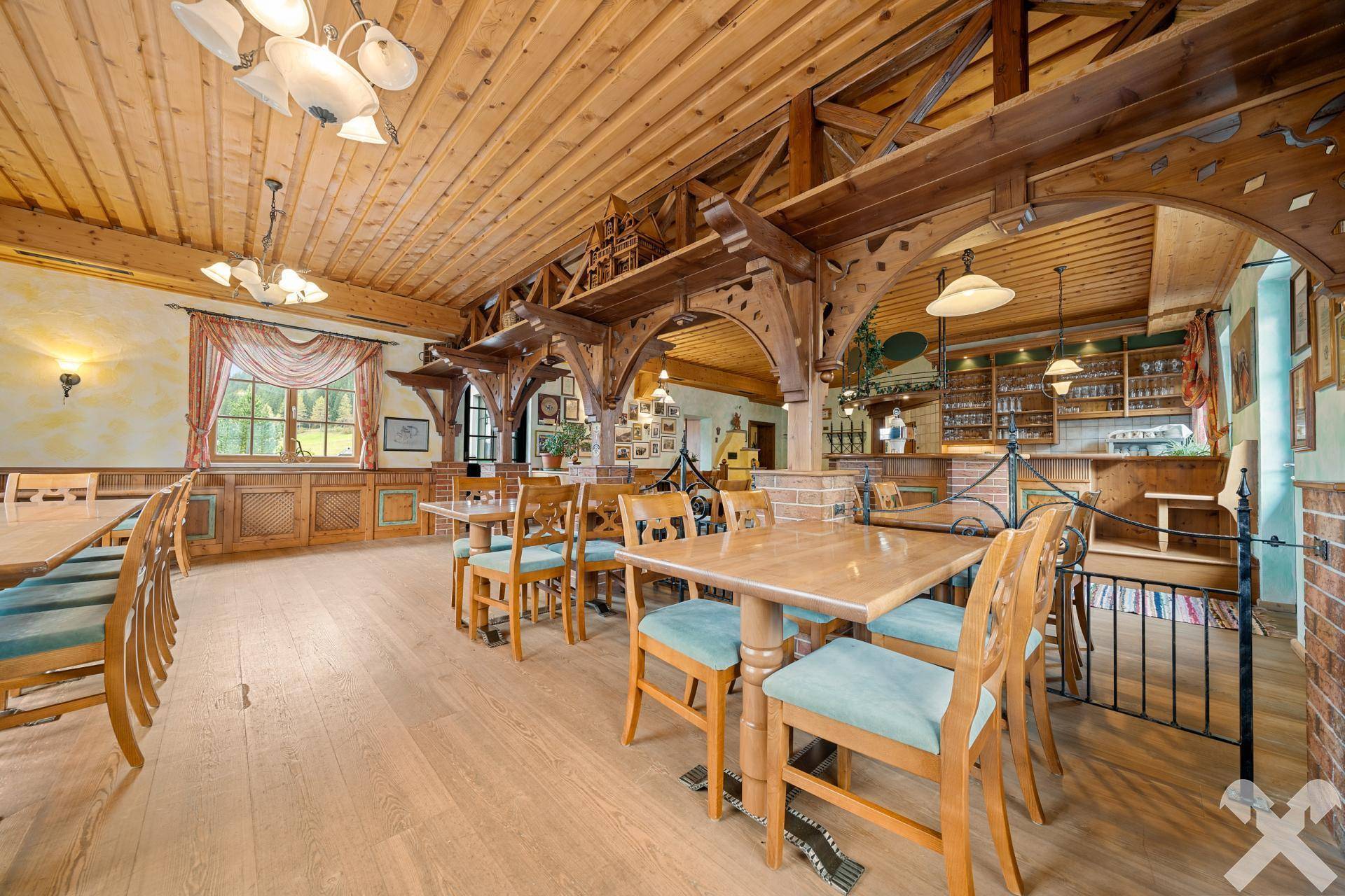 Traditioneller Speisesaal mit Holzbalken, einer Bar und rustikalen Sitzgelegenheiten, ideal für gesellige Runden und Feiern.