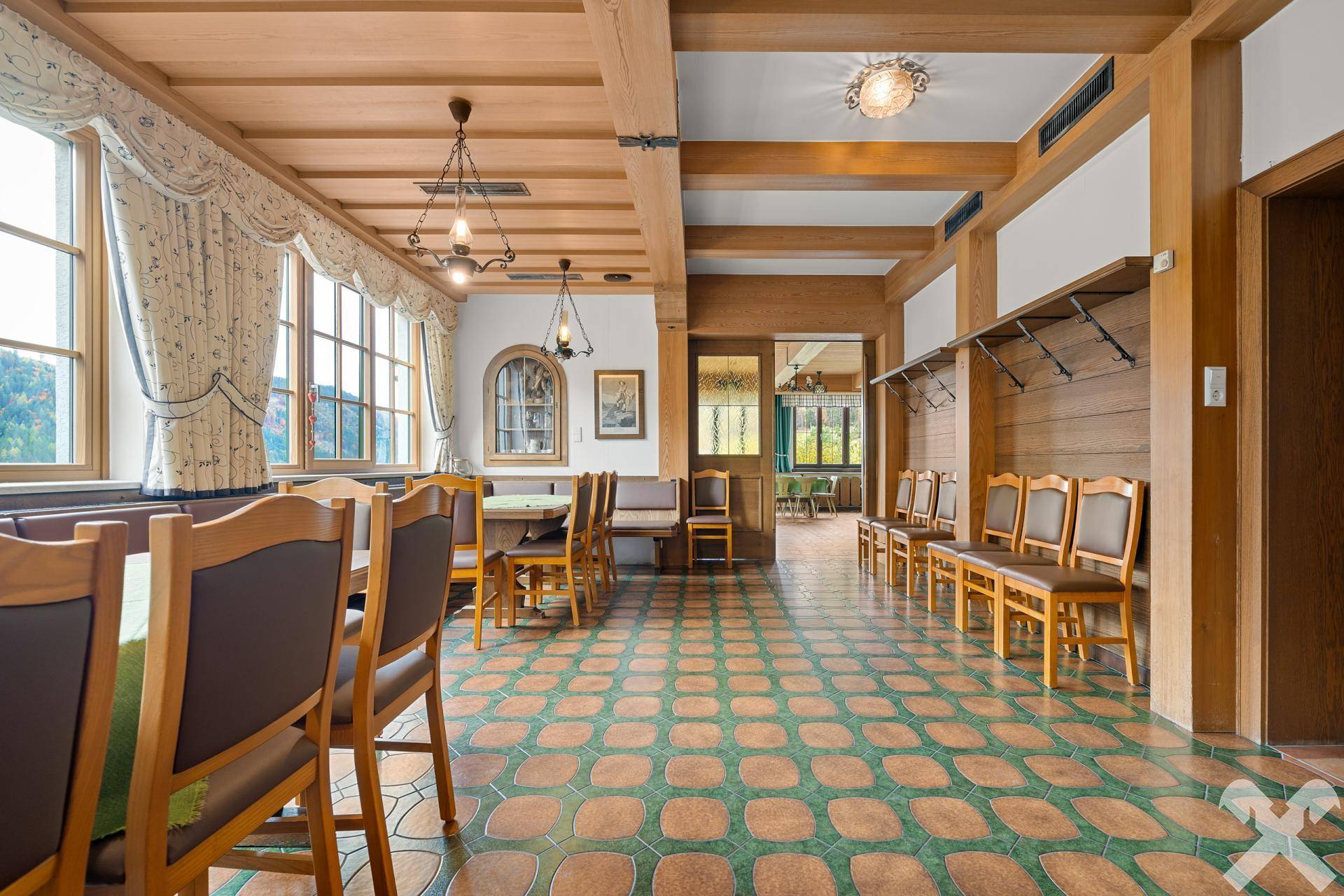 Großer Essbereich mit Holzbalkendecke, gemustertem Fliesenboden und traditionellen Holzmöbeln, hell und einladend.