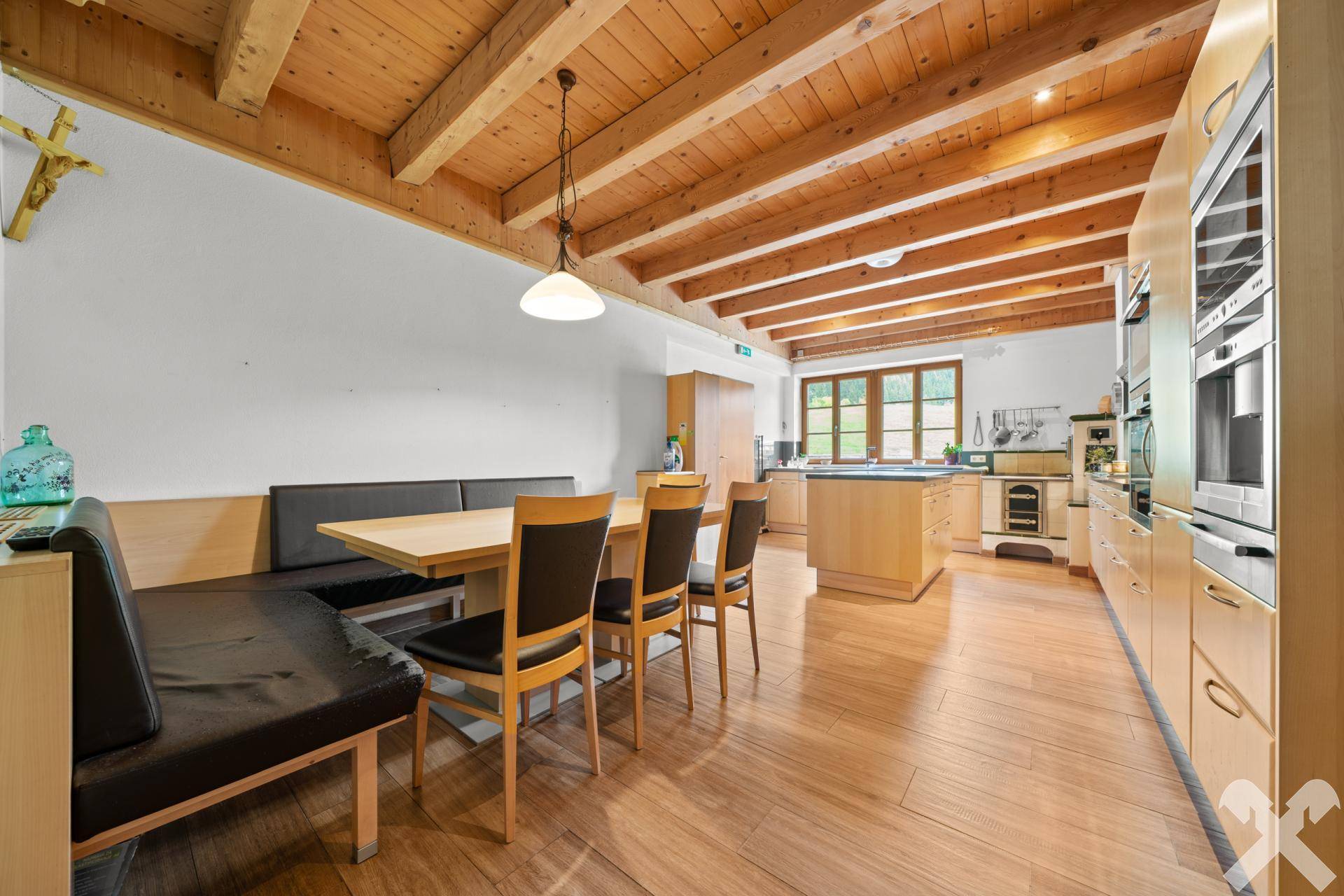 Geräumiger Essbereich mit Holzbalkendecke, Holzboden und Sitzbank, offen zur modernen Küche, ideal für Familien.