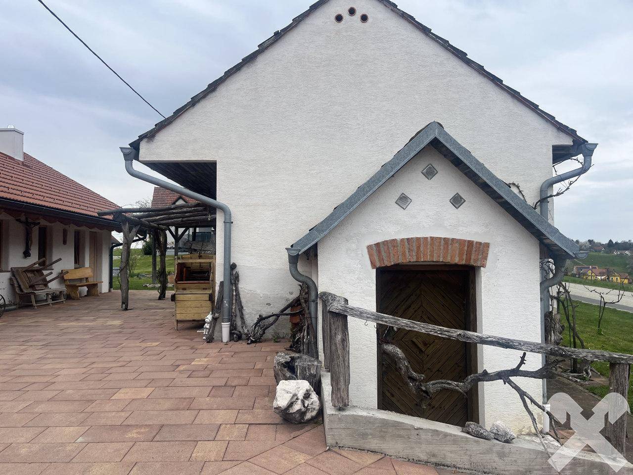 Kleines Nebengebäude mit rustikaler Holztür und traditioneller Architektur im Außenbereich.
