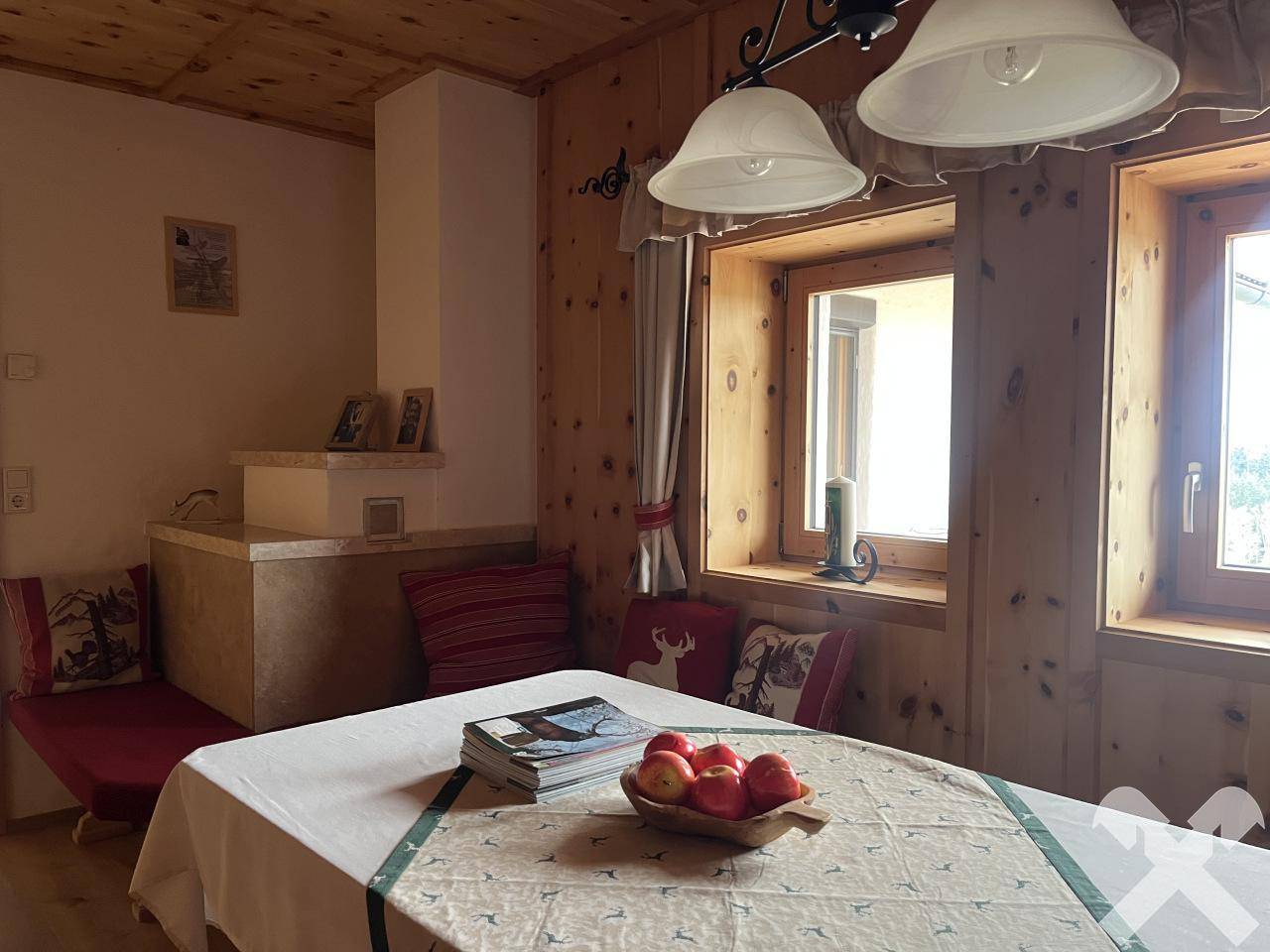 Gemütlicher Essbereich im alpinen Stil mit Holztäfelung, Kachelofen und traditionellen Sitzgelegenheiten.